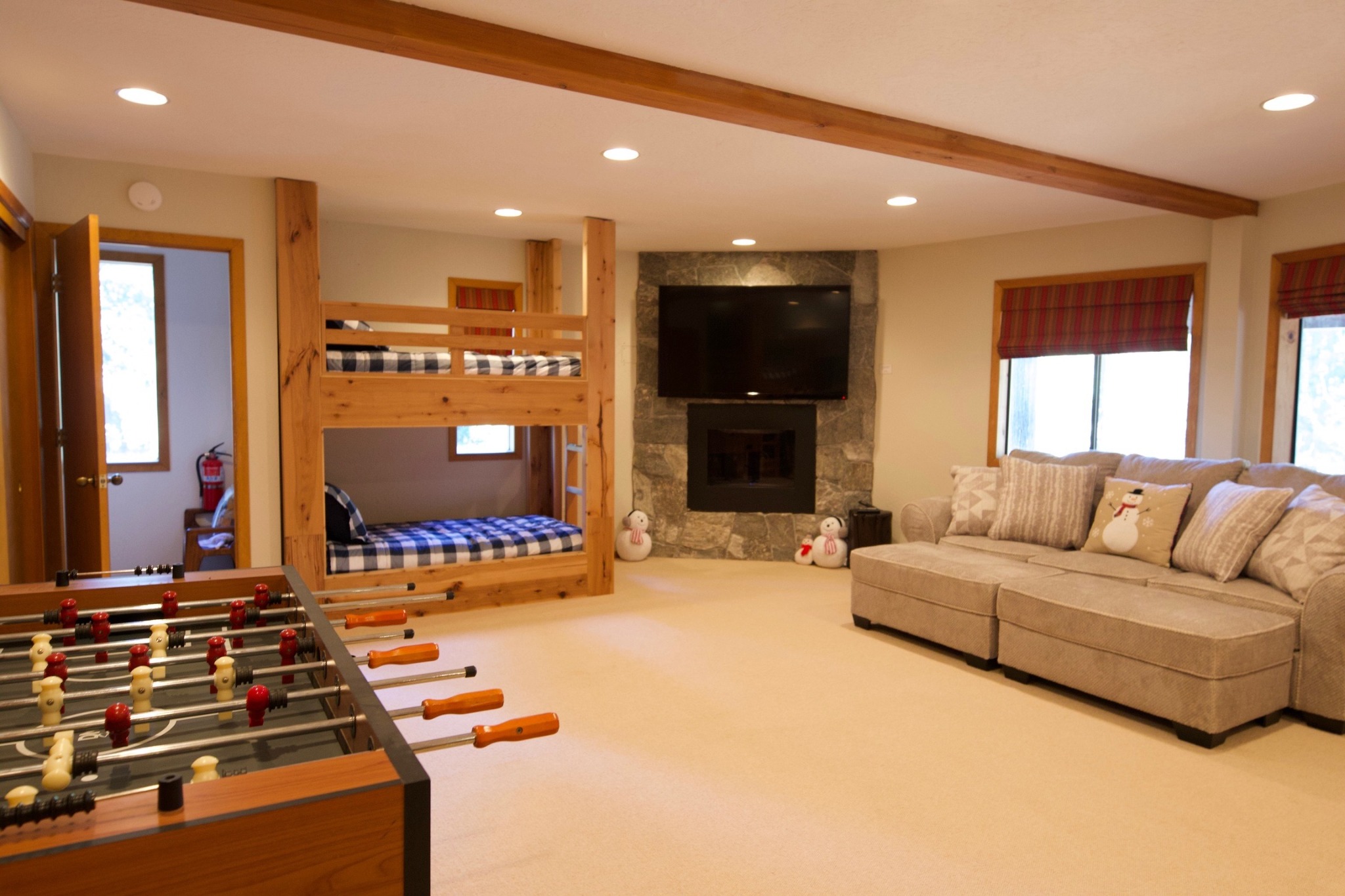 Bunk and game room with foosball, fireplace and lounge seating